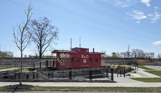 A RED CABOOSE TRAIN CAR SITTING ON A TRACK IN WORTHINGTON OHIO