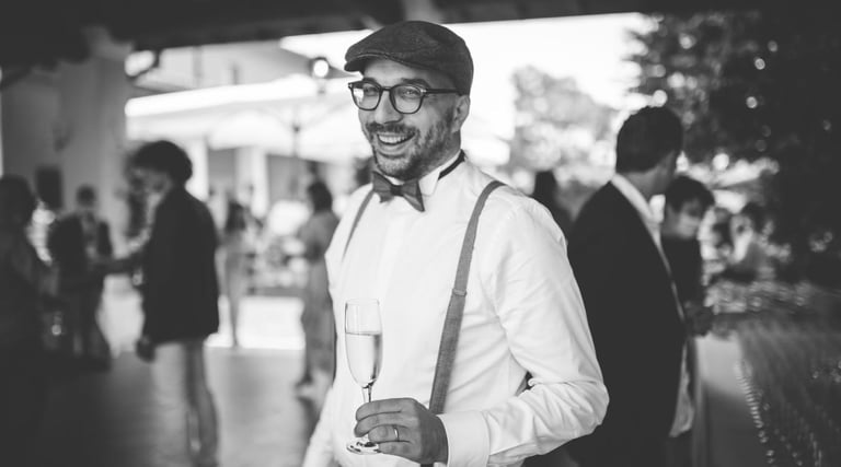 a man in a suit and bow tie smiling