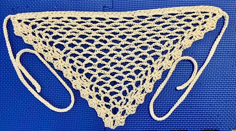 Crochet bandana belt in a natural color laid out flat showing lacy stitches