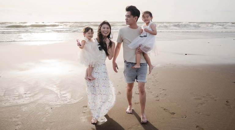 Family walking together toward the camera during a relaxed family photography session at Petitenget Beach Seminyak Bali