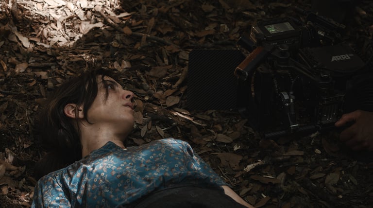 a woman laying on the ground with a camera and a camera