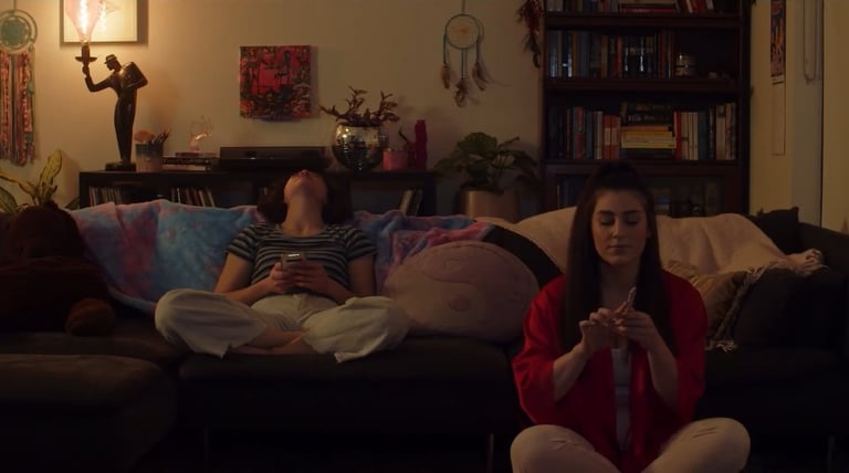 a woman sitting on a couch with a man and a woman