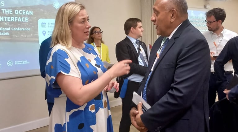 Filimon Manoni and Jutta Urpilainen are discussing in front of an IPOS presentation
