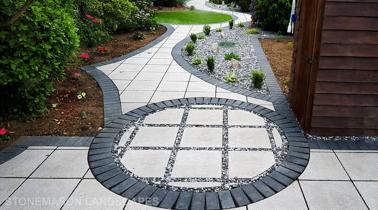 Patio with custom stone circle with aggregates and paving weaving through adventurous garden design