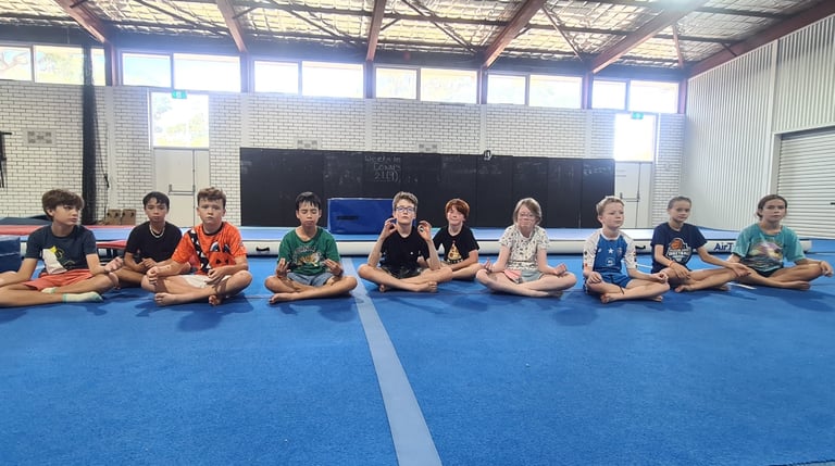 a group of children sitting on a blue mat