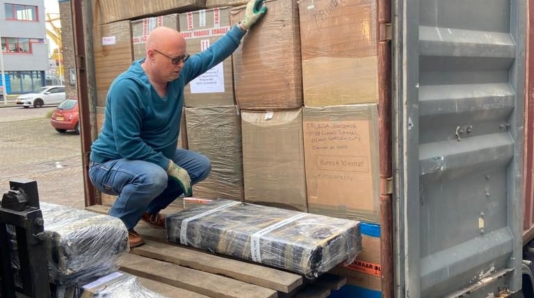 a Fred Nieberg  is standing on a container truck with a lots of Pinoy Balikbayan Boxxes