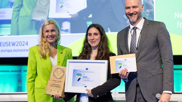 a man and woman holding a plaque in front of a screen
