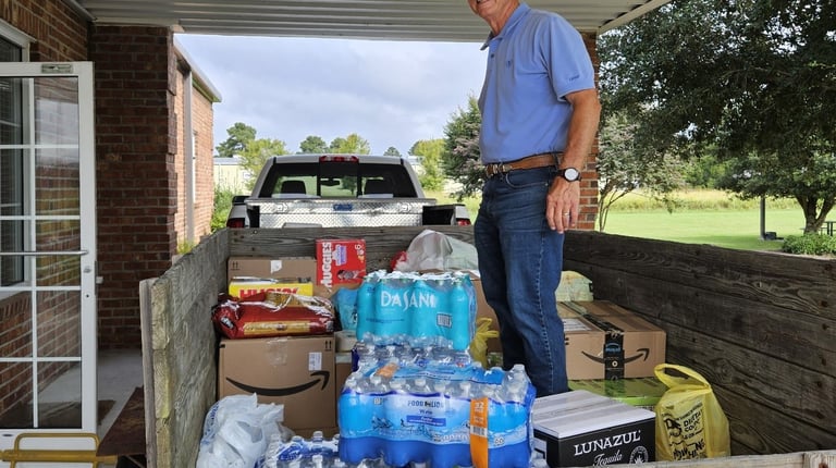 Man standing on a trailer with donations for western NC hurricane relief