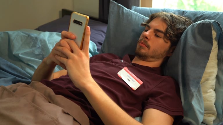 a man laying on a bed with a name tag on it