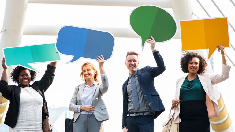 Colaboradores segurando balões de comunicação simbolizando comunicação eficiente empresarial