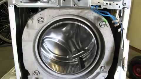 Front panel of a washer is removed for pump repair