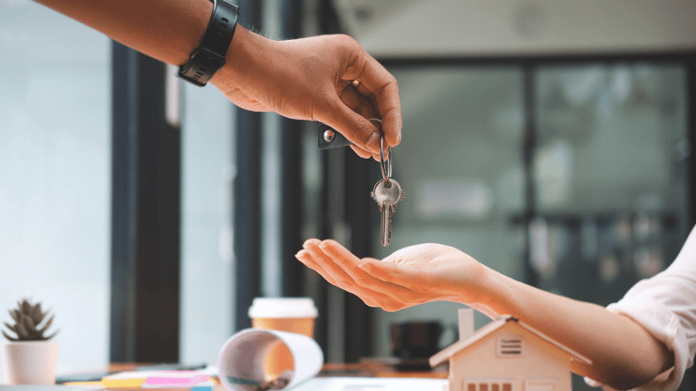 a person handing a keychaik to a house