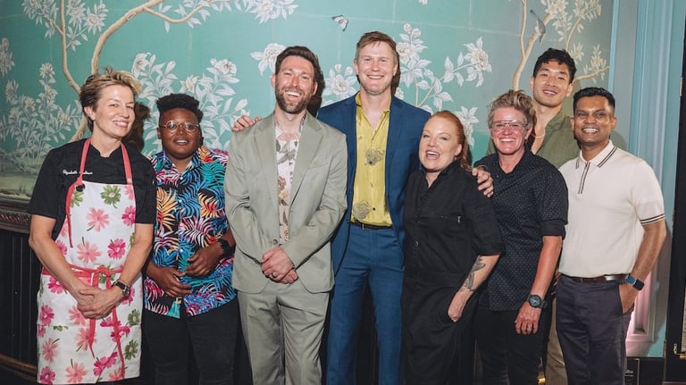A group of chefs and BQFF founders standing in front of a wall with a wall with a mural