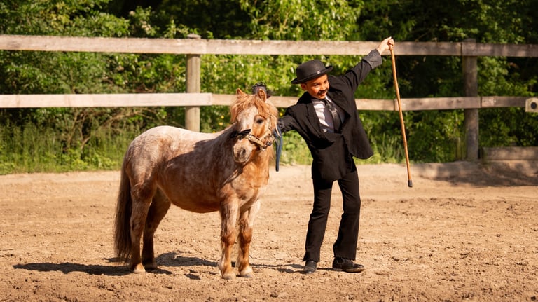 a girl in a suit and hat standing next to a horse