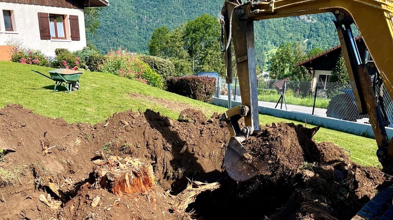 a bulldozer digging a hole in the grass