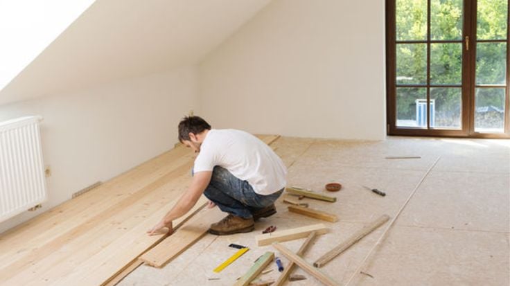 illustration d'un ouvrier posant du parquet en bois massif dans une pièce baignée de lumière 