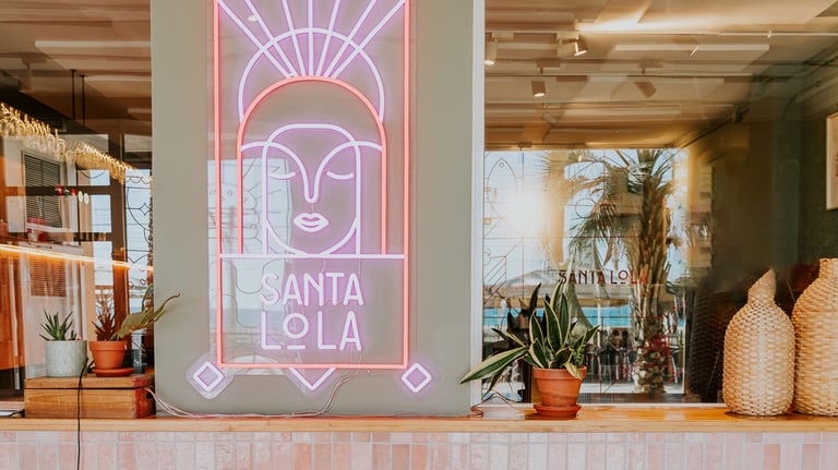 Interior of Santa Lola restaurant with pink neon lights