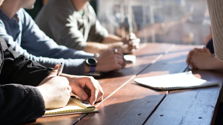 A meeting showing a group of people sitting at a table