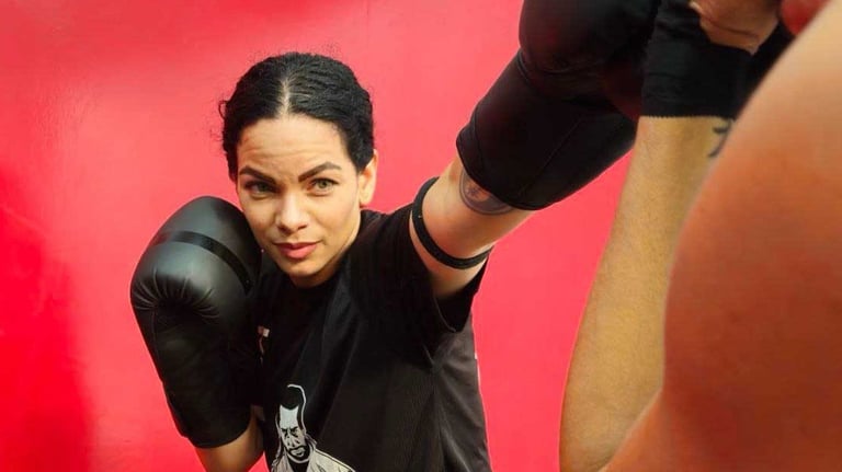 a woman in a boxing gloves is posing for a picture
