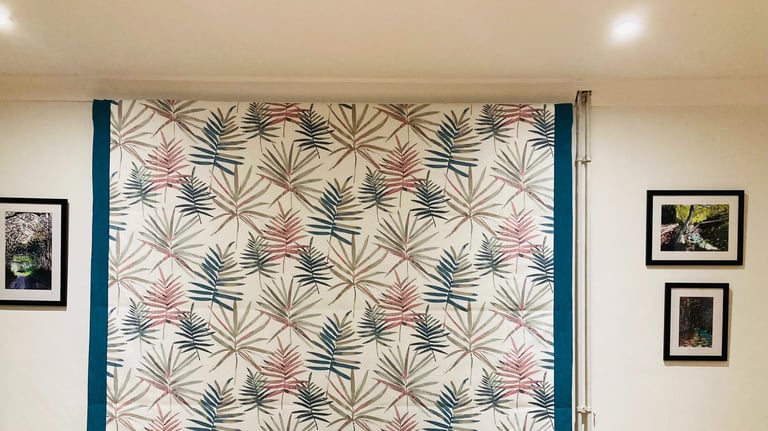Picture of roman blind that is down that has borders both sides to emphasise one of the colours in the main fabric