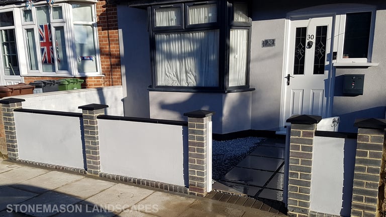 Blue perfurated brick wall with black coping and caps and grey rendering