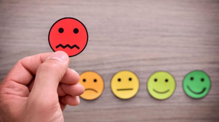 Carinhas com níveis emocionais de triste a feliz simbolizando feedbacks empresariais