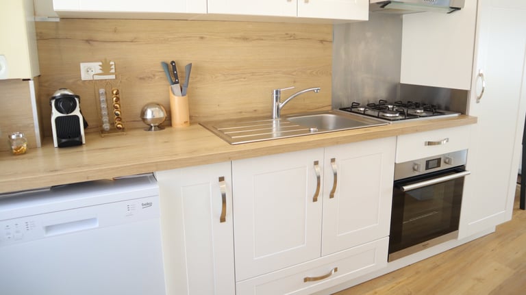 Cuisine équipée avec électroménagers modernes dans logement meublé pour professionnels.