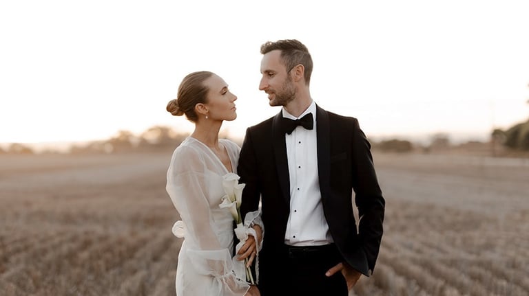 a bride and groom standing in a field at Woodburn Homestead
