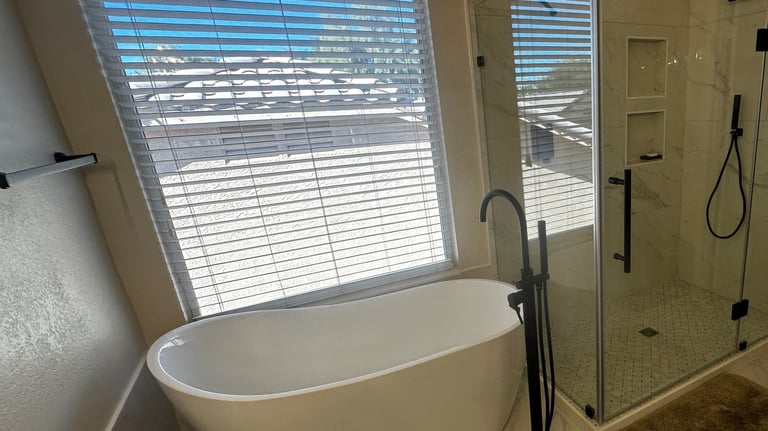 a remodeled bathroom with a stand alone tub and a walk in shower