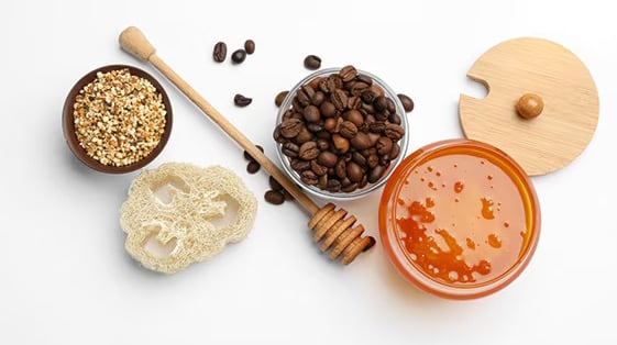 Natural skincare ingredients including coffee beans, honey, and grains – DIY exfoliating concept