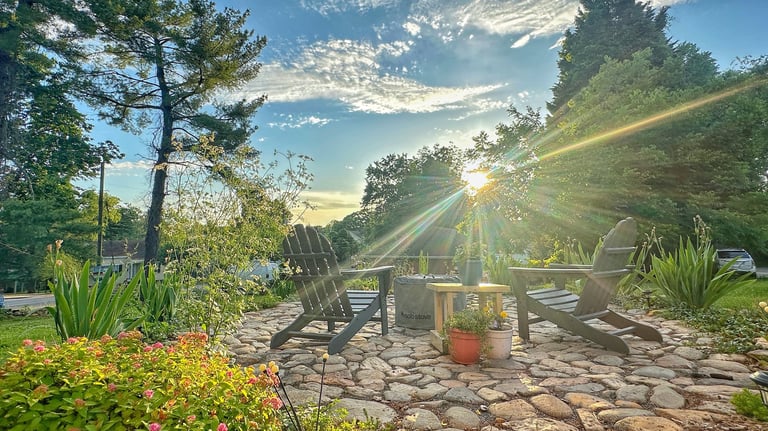 a patio with chairs and a fire pit