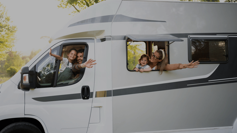 a family of four people are sitting in a camper van