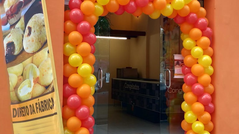 Arco de balões decorando entrada de loja em inauguração com cores personalizadas.