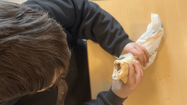 élève qui mange un sandwich