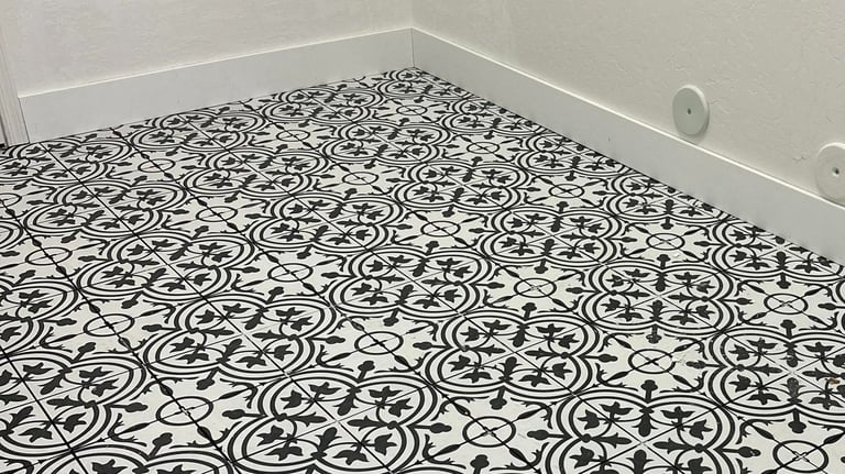 Installed tile flooring with new baseboards in laundry room