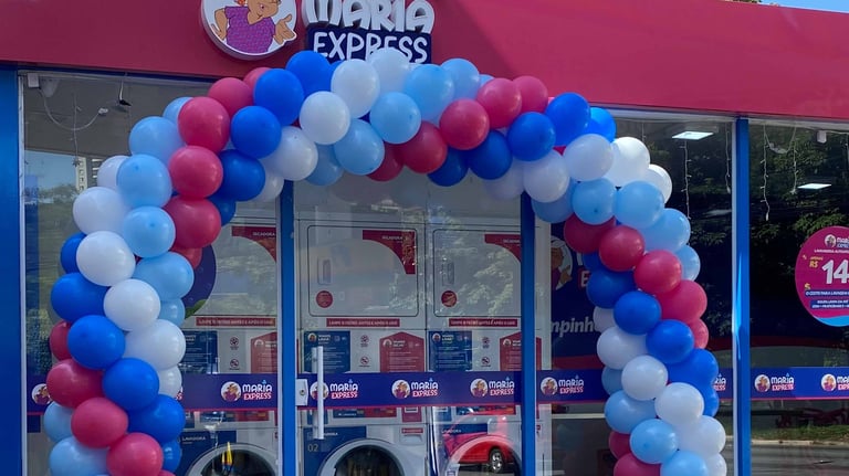 Arco de balões elegante em evento corporativo, destacando fachada da empresa.