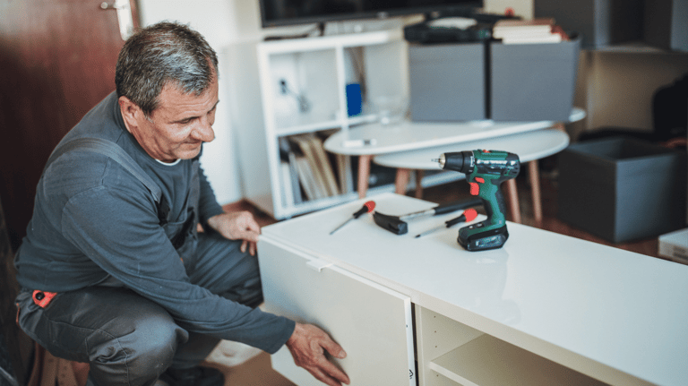 a man in a gray shirt is holding a drillet