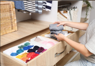 folded clothing sorted into drawer organizer during home organization
