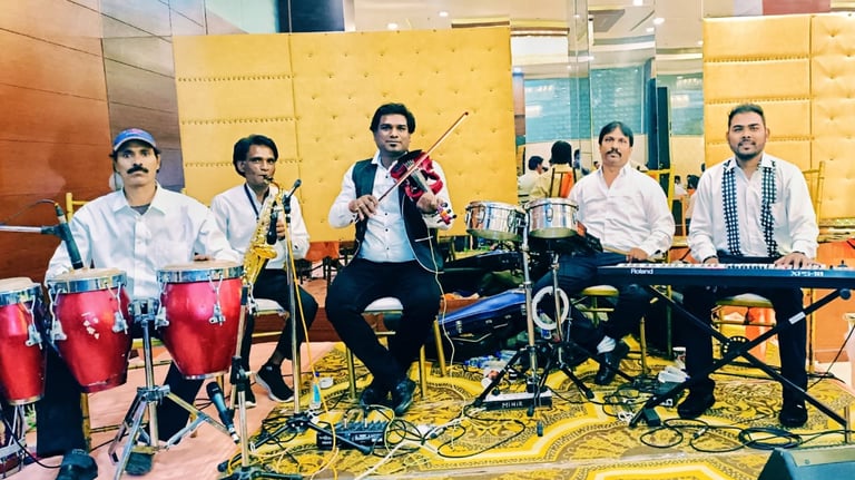 Live band musicians performing with violin, keyboard, saxophone, and conga drums at a formal event.