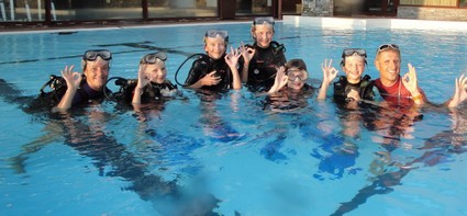 a group of people in scuba gear standing in a pool