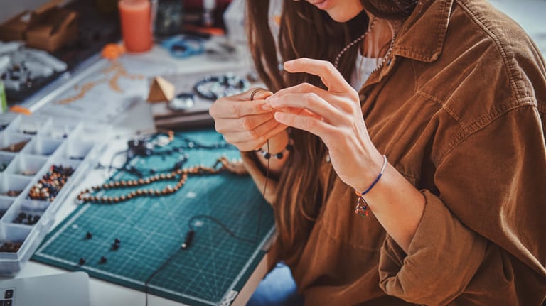 Alumna haciendo pulsera con cuentas de piedras