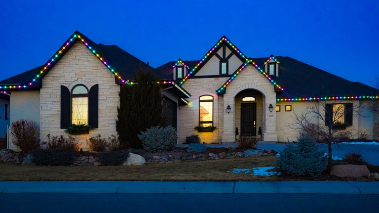 Luxury home featuring colorful LED Christmas roof lights and festive holiday outdoor lighting.