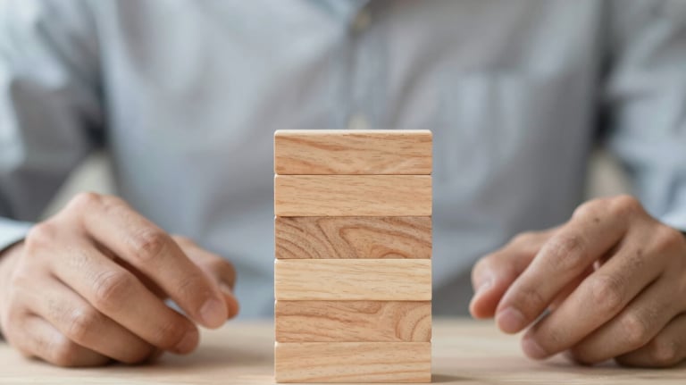 Close up of hands stacking wooden blocks together, symbolizing growth and values, soft lighting, professional metaphor.