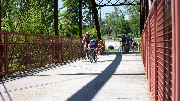Photo of bikers coming over a bridge from the front of the pack