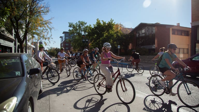 Group of women on bikes riding on a downtown street