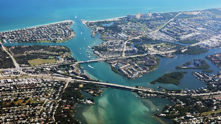 a bridge spanning a river with a bridge in the background. Black car Service jupiter florida