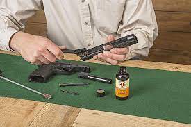 Cleaning a disassembled firearm with the correct tools and chemicals.