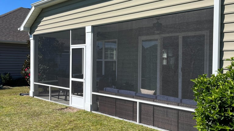 Comfortable screen porch seating with outdoor furniture and throw pillows