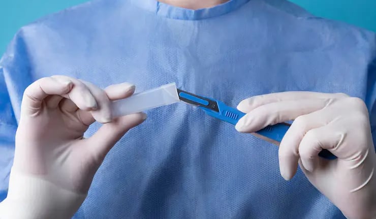 a person in a blue shirt and gloves holding a piece of paper