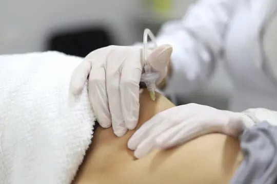 a person in a white shirt is getting a tattoo on their back